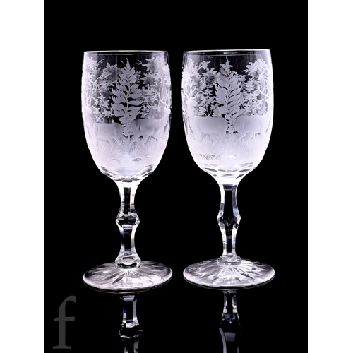 517 - A pair of late 19th Century Stourbridge clear crystal goblets, the ovoid bowls engraved in the Bohem... 