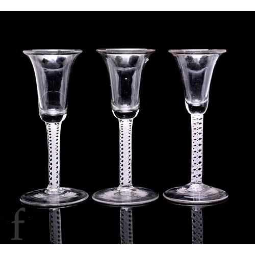 751 - A group of three 18th Century continental drinking glasses, each with slender bell form bowl with ev... 
