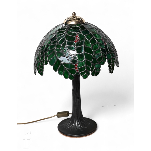 712 - A Tiffany style table lamp and shade, the green umbrella canopy interspaced with fruit within leaded... 