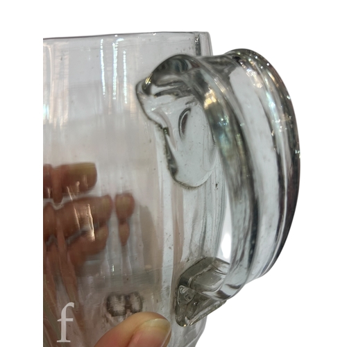 146 - A late 18th Century glass tankard, the swollen barrel form body with vertical fluted and an applied ... 