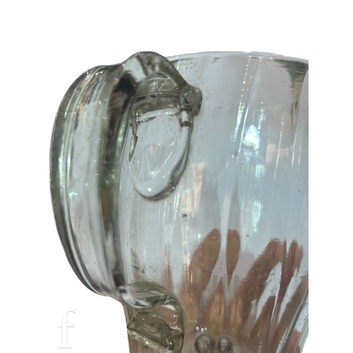 146 - A late 18th Century glass tankard, the swollen barrel form body with vertical fluted and an applied ... 
