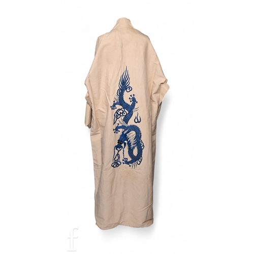 88 - An Asian 20th Century embroidered robe/kimono, blue dragon design on a cream ground.