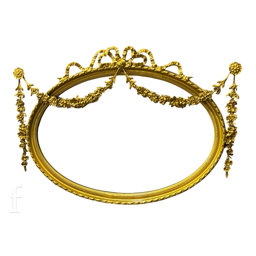 1244 - An early 20th Century gilt framed oval bevelled wall mirror, with tied ribbon swags and garlands to ... 