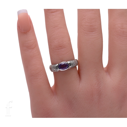55 - An amethyst and diamond 9 carat gold stone set dress ring, the central amethyst flanked by two diamo... 