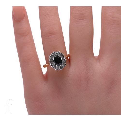 8 - A sapphire and diamond cluster ring, the oval mixed-cut sapphire of green/blue colour, eight claw se... 