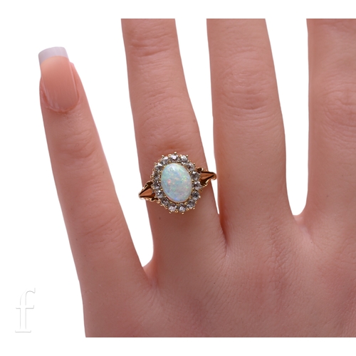 14 - An opal and diamond ring, the oval cabochon-cut opal within a border of old brilliant-cut diamonds, ... 