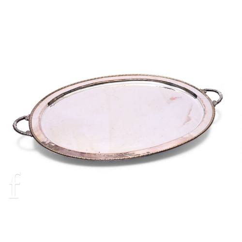 567 - An Arts & Crafts oval plated two handled serving tray, raised border and acanthus leaf handles, ... 