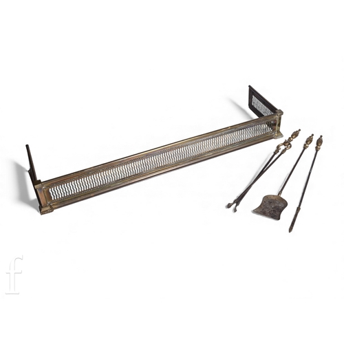 744 - A pierced brass fender, length 124cm, and a set of three brass fire irons. (4)