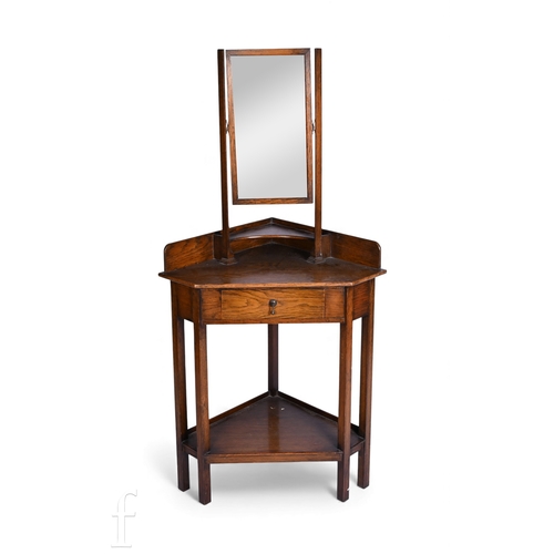762 - In the manner of Liberty, an oak corner washstand with swing mirror over a single drawer on square l... 