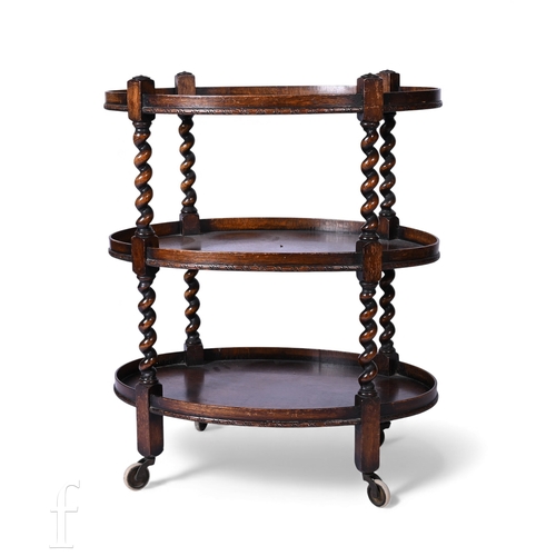 848 - A 1920s oak three tier oval serving trolley on barleytwist supports, height 86cm and width 72cm, tog... 