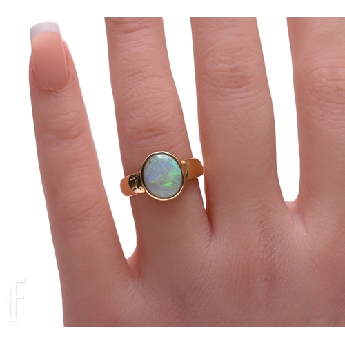 7 - An opal and 18ct gold ring, the oval cabochon-cut opal, collet set on gold band, marked 