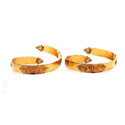 99 - A pair of gold bangles, with foliate detail against a textured ground, total weight 65g.