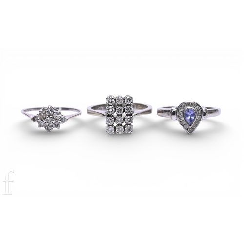 125 - A tanzanite and diamond ring, the pear-cut tanzanite collet set within a diamond set mount, hallmark... 