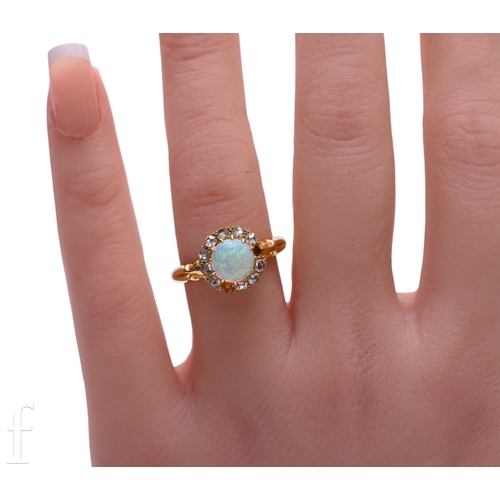 29 - An opal and diamond ring, the circular-cut opal cabochon, within a border of old brilliant-cut diamo... 