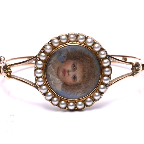 13 - A late Victorian gold and seed pearl double locket bangle, circa 1890, the circular locket with half... 