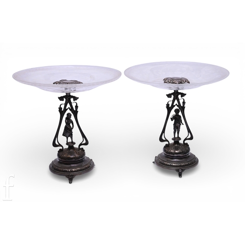 375 - A pair of late 19th Century WMF silver plated figural comports, with etched circular glass bowls on ... 