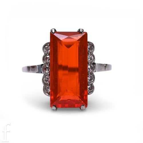 181 - Liberty & Co; a fire opal ring, circa 1900, the step-cut fire opal, four claw set between diamon... 
