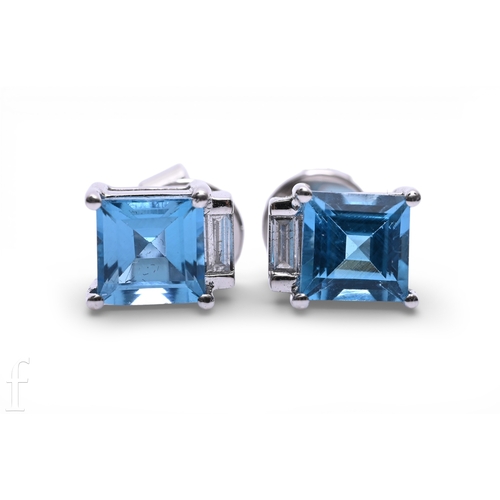 135 - A pair of blue topaz and diamond earrings, the square step-cut topaz four claw set with a baguette-c... 