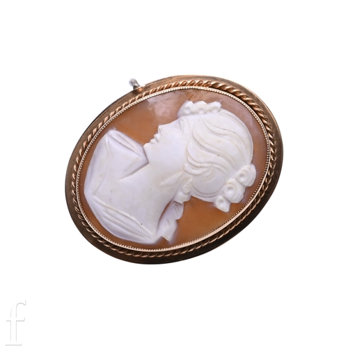 61 - A shell cameo brooch, the oval cameo carved to depict the profile of a lady within a ropework and pl... 