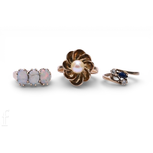 140 - A three stone opal ring, the three oval cabochon-cut opals, claw set in a plain mount, hallmarked fo... 