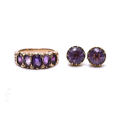148 - A five stone amethyst ring, the graduating row of five oval mixed-cut amethysts, within a carved mou... 