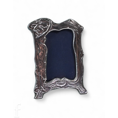 569 - A modern hallmarked silver easel photograph frame, decorated with an Art Nouveau lady holding reachi... 