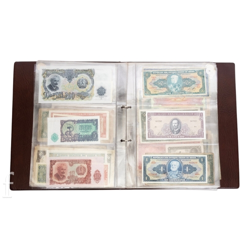 49 - Banknotes - An album of assorted world notes to include a 1965 Nigerian one pound note, Bulgarian St... 