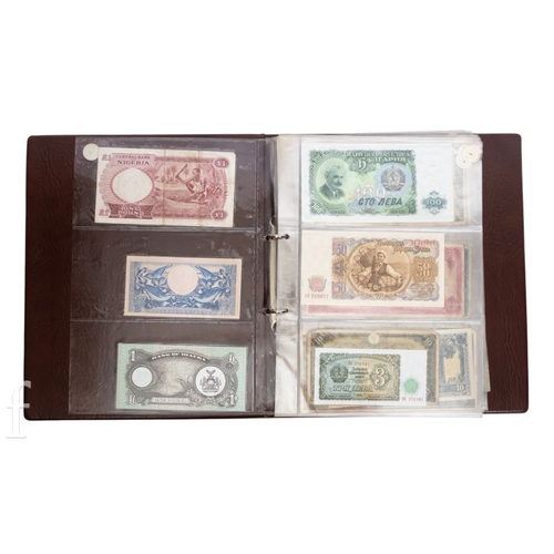 49 - Banknotes - An album of assorted world notes to include a 1965 Nigerian one pound note, Bulgarian St... 