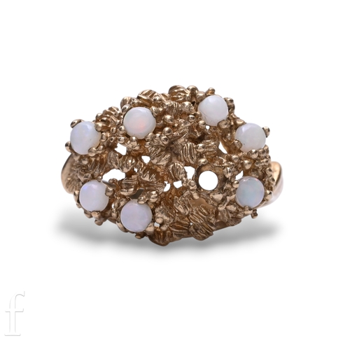 119 - A 9 carat gold and opal Brutalist ring, circa 1970, the textured ring set with seven circular caboch... 
