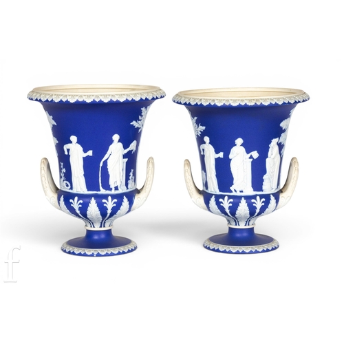 801 - A pair of Wedgwood jasperware urns, twin handled campana form on circular foot, sprig decorated with... 