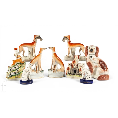 821 - A pair of 19th Century Staffordshire figures, coursing hounds with game, rust red coats, on naturali... 