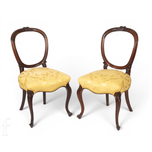 1581 - A set of four Victorian carved walnut salon chairs on slender cabriole legs terminating in scroll fe... 