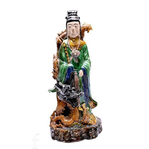 1254 - A Ming style sancai glazed figure of a Chinese Immortal, dressed wearing robes and with a dragon at ... 