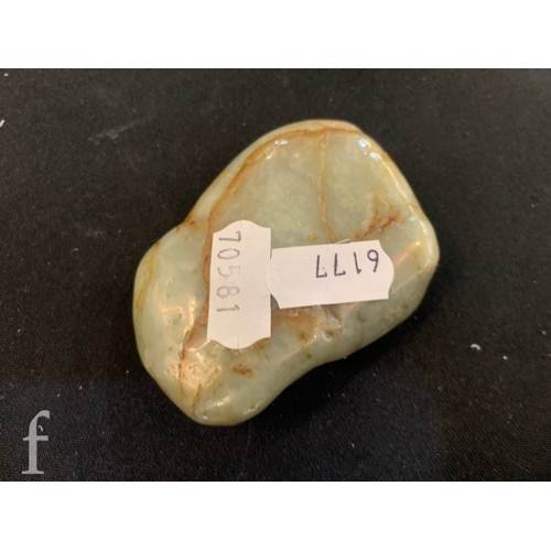 1291 - A Chinese green hardstone pebble carving of a horse under lotus flower, the polished stone carved in... 