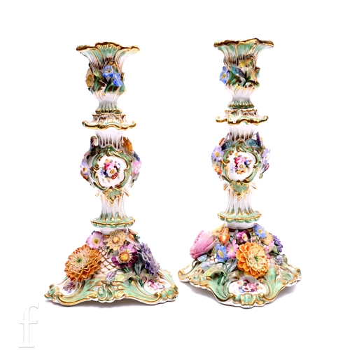A pair of 19th Century Coalbrookdale candlesticks, each with shaped ...