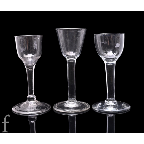21 - An 18th Century drinking glass circa 1750, the round funnel bowl above a solid plain stem, raised to... 