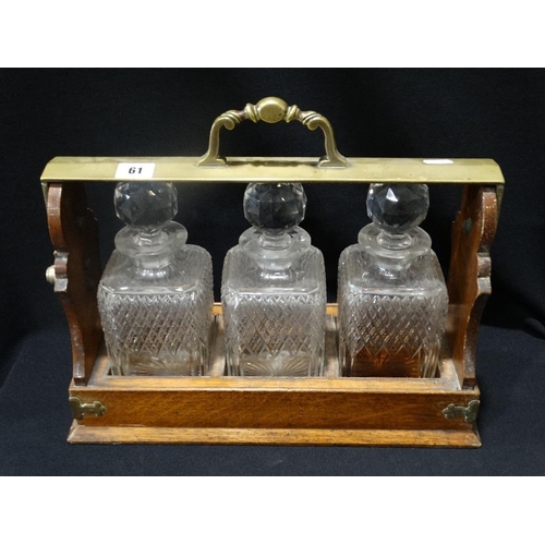 61 - An Edwardian Oak Three Bottle Tantalus With Plated Mounts