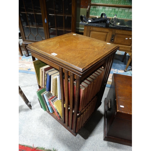 546 - A Late Victorian Oak Revolving Bookcase Containing A Selection Of Vintage Books