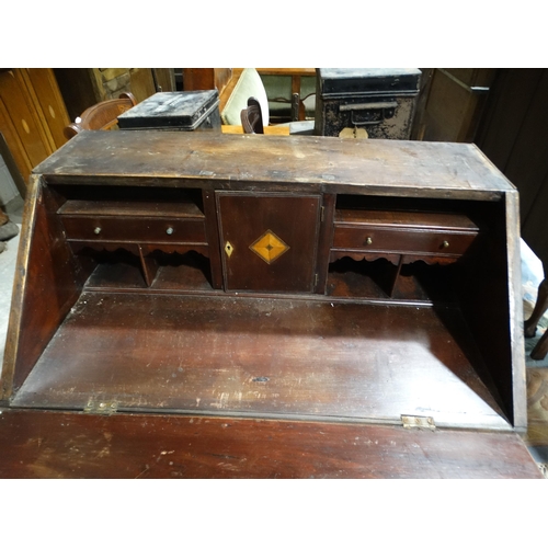 570 - An Antique Oak Bureau With Three Drawers To The Base