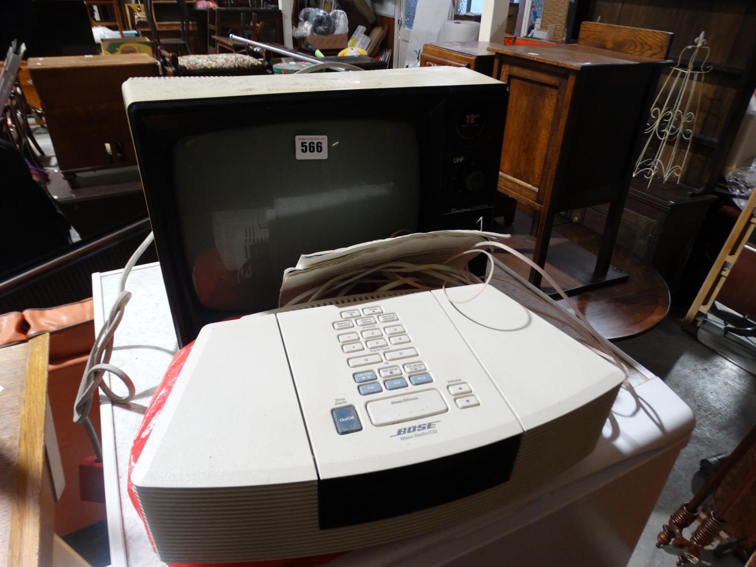A Retro Portable Television Together With A Bose Clock Radio