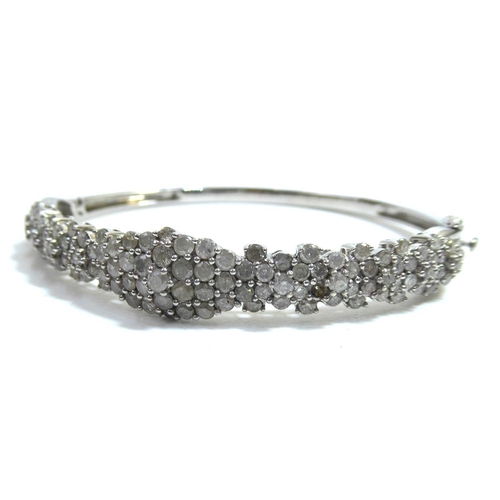 272 - A 20th CENTURY SILVER AND MULTI DIAMOND BANGLEset with round cut stones in a tapering design.Approx ... 