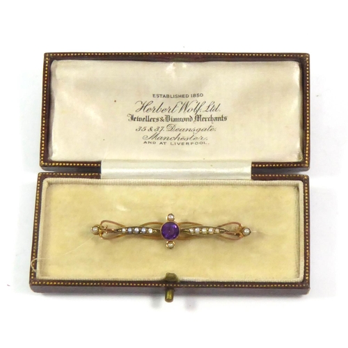 25 - A VINTAGE 9CT GOLD AMETHYST AND SEED PEARL BROOCH
The single round cut amethyst flanked by graduatin... 