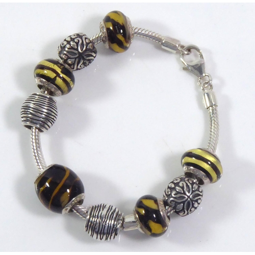 71 - LOVELINKS, A SILVER AND MURANO GLASS BRACELET
The fancy spherical links set with yellow and black gl... 