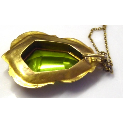 87 - A VICTORIAN YELLOW METAL, PERIDOT AND SEED PEARL PENDANT
Having a lozenge form stone in a scrolled m... 