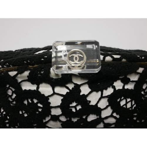 422 - CHANEL, A BLACK AND WHITE COTTON AND SATIN FLORAL LACE LARGE FRAMED CLUTCH
With lucite monogrammed c... 