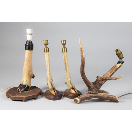 104 - AN EARLY 20TH CENTURY TAXIDERMY GROUP, COMPRISING OF A PAIR OF BRASS MOUNTED DEER FOOT CANDLESTICKS,... 