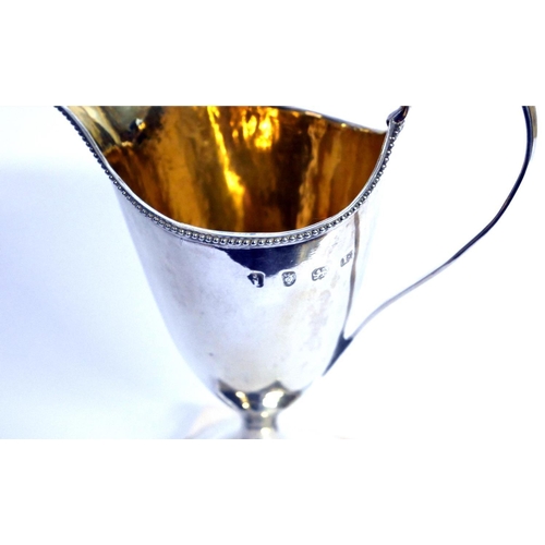 430 - A GEORGIAN SILVER CLASSICAL HELMET FORM CREAM JUG
With beaded rim and gilt interior, hallmarked Lond... 