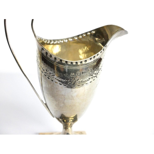 431 - A GEORGIAN SILVER CLASSICAL HELMET FORM CREAM JUG
With fine engraved decoration and square base, hal... 