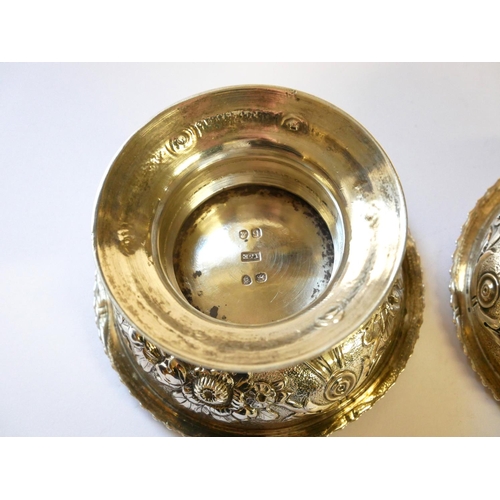 442 - A PAIR OF GEORGIAN SILVER CIRCULAR SALTS 
With embossed floral decoration and flared foot rim, hallm... 