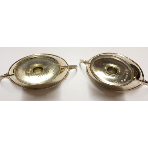 448 - A PAIR OF GEORGIAN SILVER NAVETTE FORM SALTS
With twin handles and gilt interior and engraved crest ... 